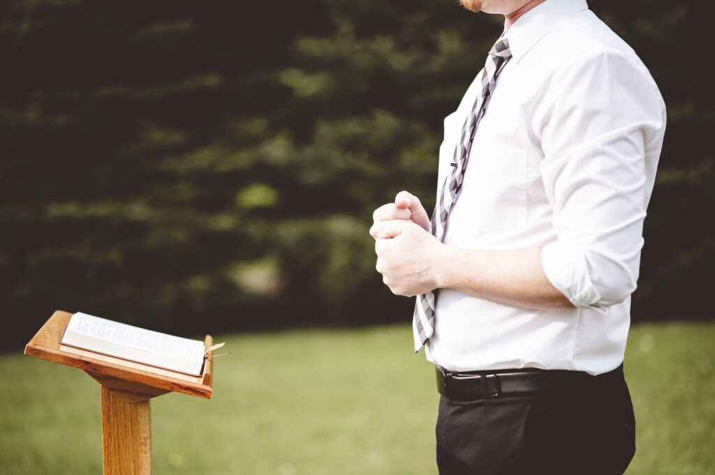 Man in White Shirt Standing Next to Podium