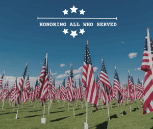 A field of flags in honor of Memorial Day. Words say Honoring All Who Served