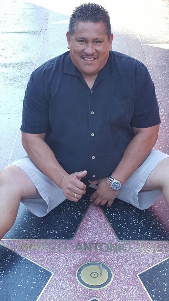 Man sitting next to hollywood star