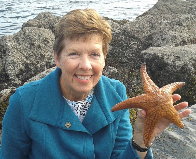 Smiling Woman in Blue Coat with Perfect Starfish
