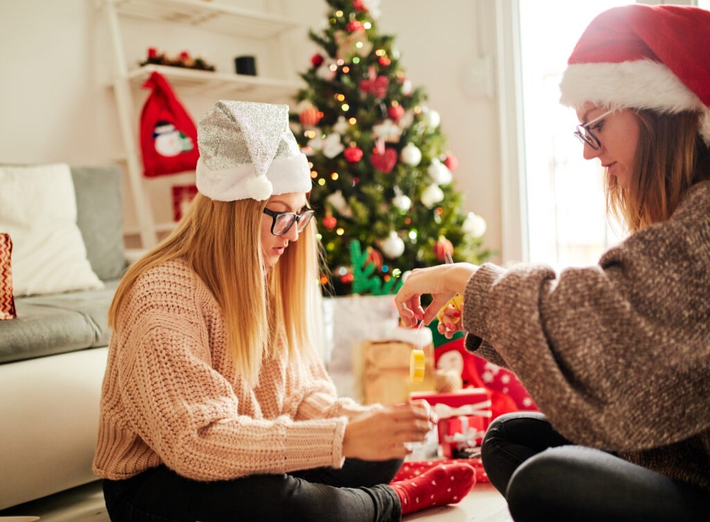 Young woman and older woman putting Christmas ornaments together