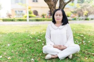 Woman sitting cross legged under a tree