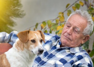 Man looking at a dog on his lap while dog looks into distance