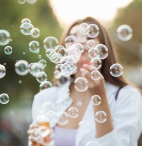 Woman blowing bubbles from a bottle.