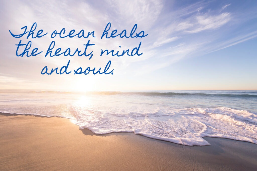 Waves on beach with "The ocean heals the heart, mind and soul" overlayed on image