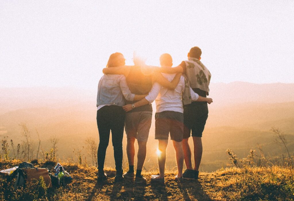 Four friends embracing and looking at a view