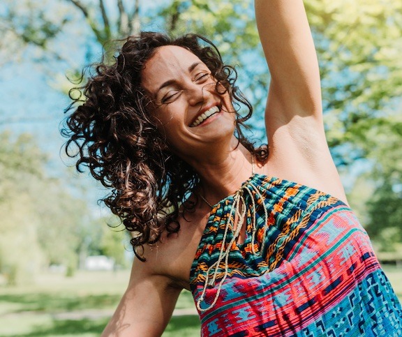 Smiling woman dancing in the sunshine