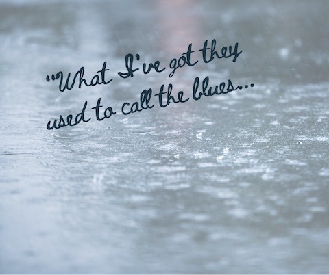 Rain on pavement with the words "What I've Got They Used To Call The Blues.."