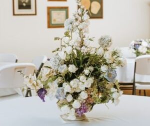 White flower vase arrangement at the center of a table