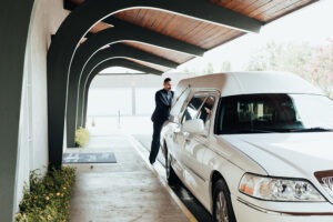 man closing funeral coach door