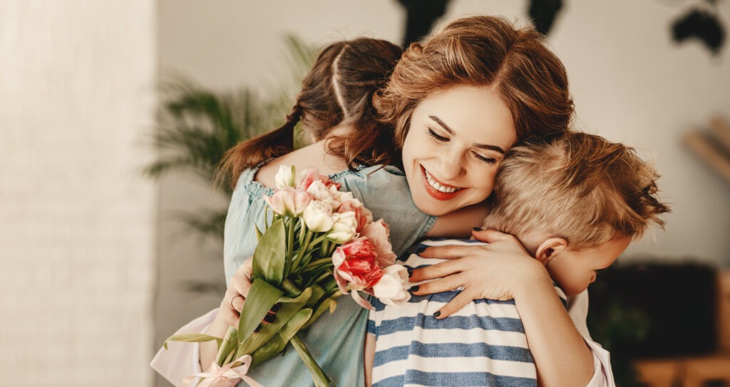 Woman hugging two children